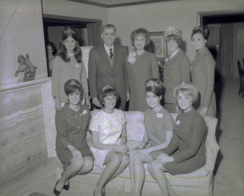 Original caption: "Big 8 Homecoming queens with Chancellor Hardin." Hardin and Martha Hardin stand with three homecoming queens while four of the queens are seated in front of them.