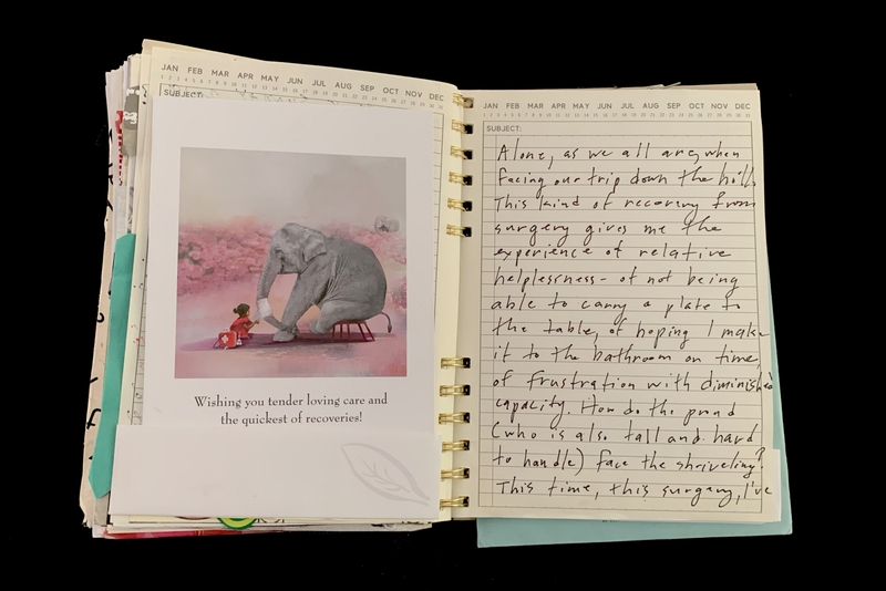 : A handwritten note in a spiral-bound notebook accompanied by a printed card featuring an elephant and a child.