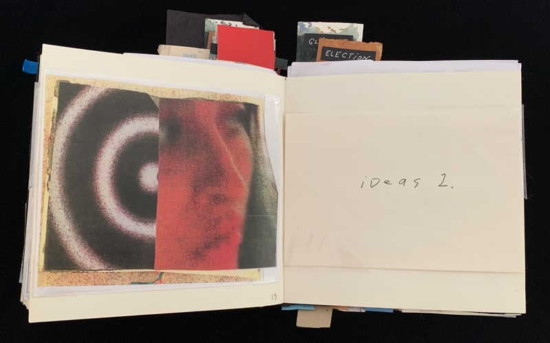 An open book with abstract art and handwritten text "ideas 2."