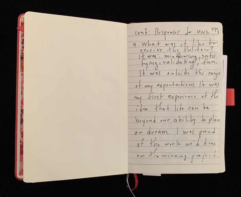 Open notebook with handwriting on the right page and a blank left page. A colorful patterned edge and a red bookmark are visible.