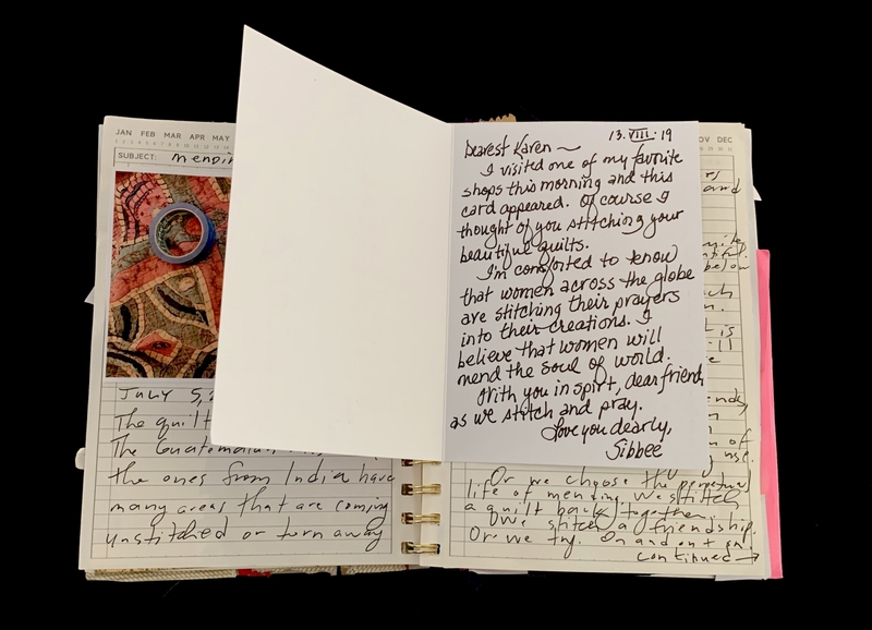 A handwritten letter with a note attached, featuring a colorful fabric sample and a ring.