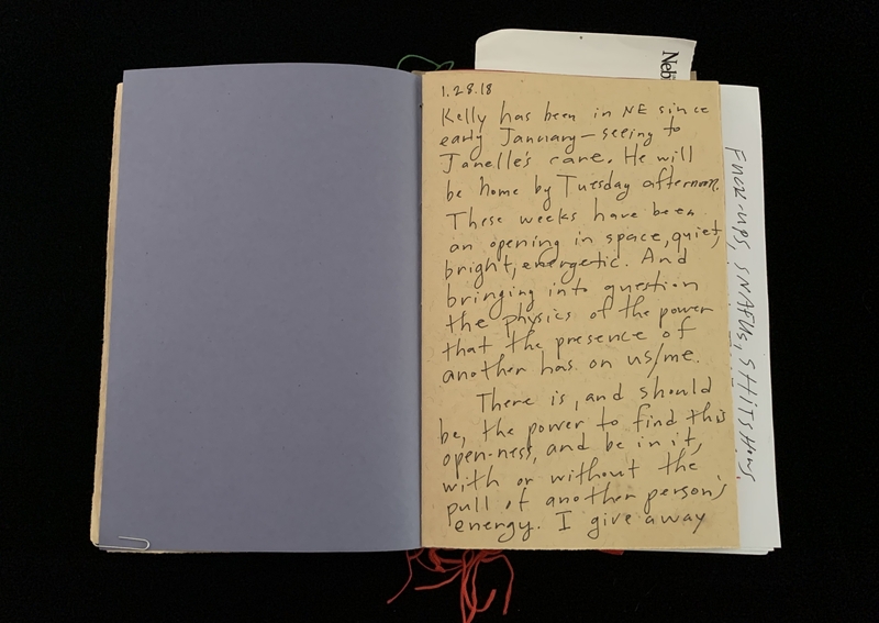 An open book with handwritten text on one page and a blank purple page opposite.