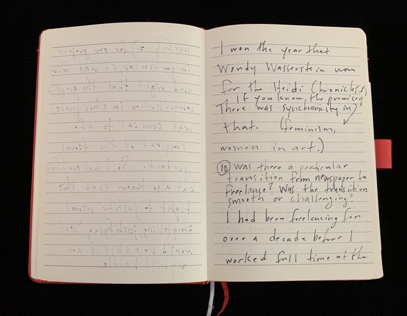 Open notebook with handwritten text on the right page and faint text on the left.