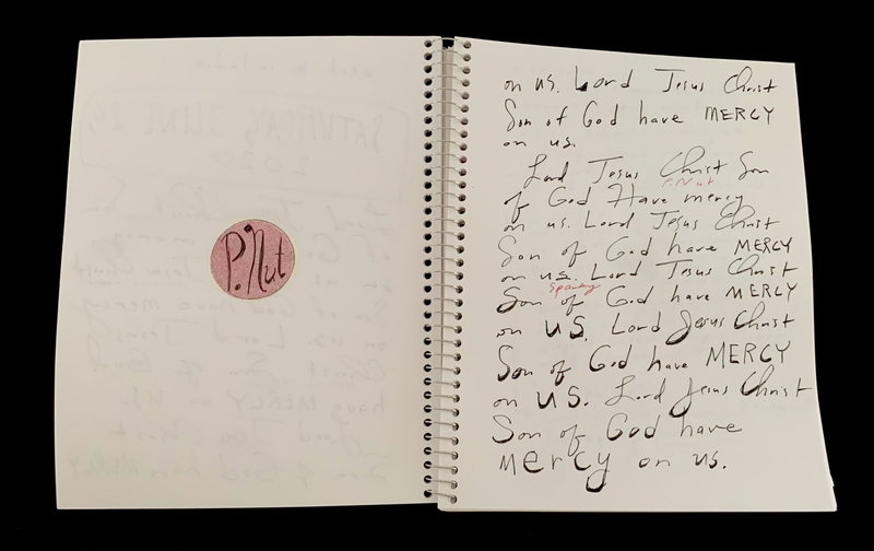 A handwritten page with a circular sticker and repeated prayers.