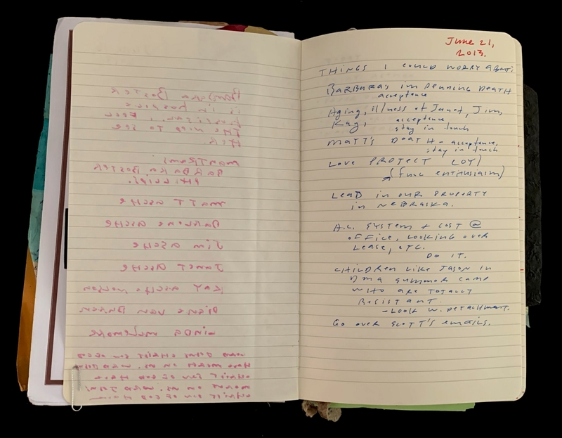 Open notebook with handwritten notes in pink and blue ink.