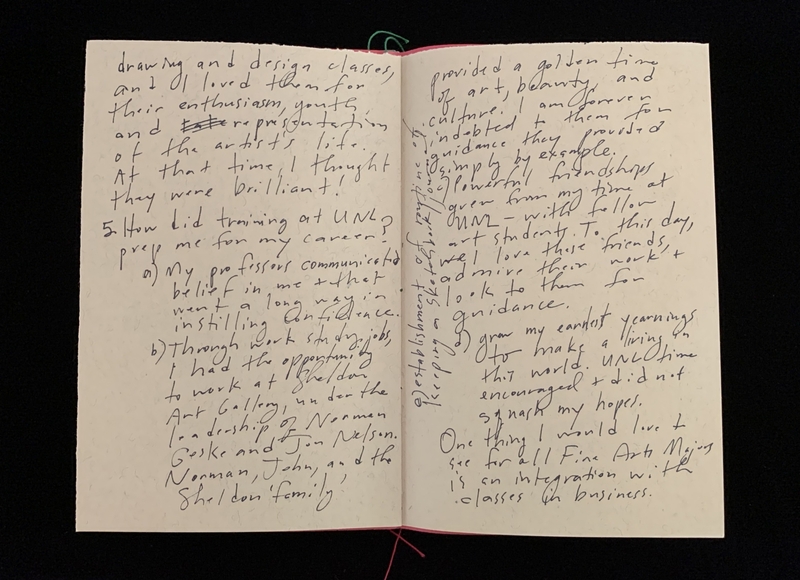 Open notebook with handwritten text on two cream-colored pages.