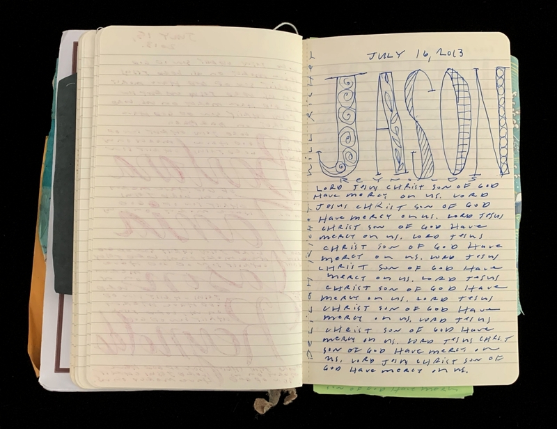 Open notebook with writing and a decorative name on one page.