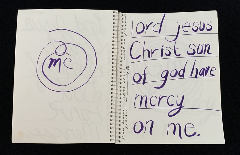 A handwritten page with a religious prayer and a simple doodle.