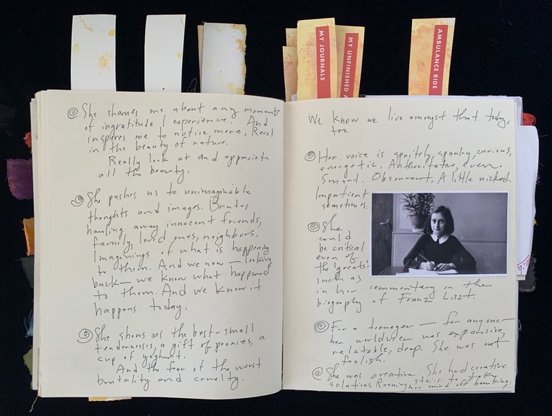 Open journal with handwritten text, a black-and-white photo of a young girl, and colored bookmarks.