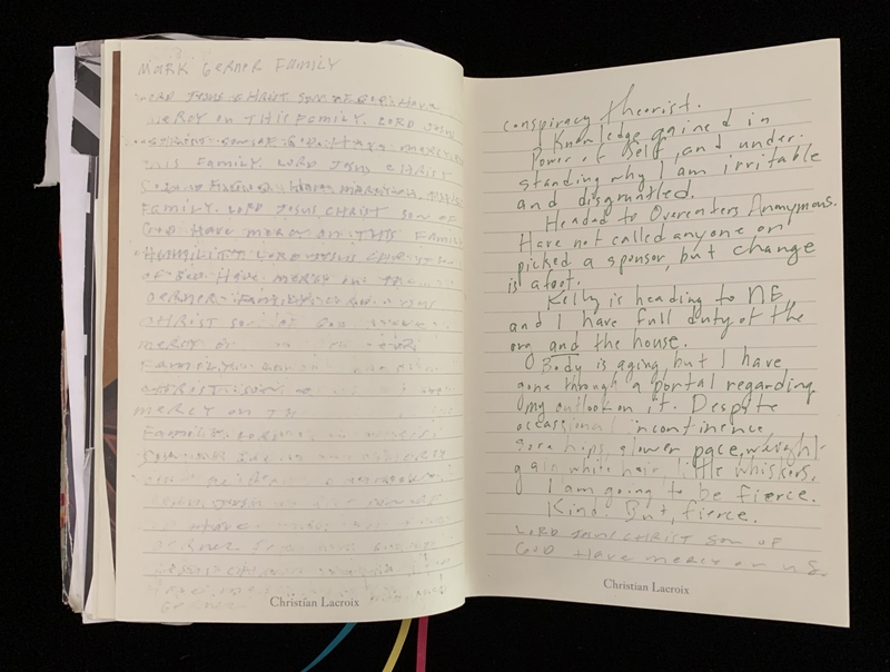 Open journal with handwritten text on both pages, the left in pencil and the right in green ink.