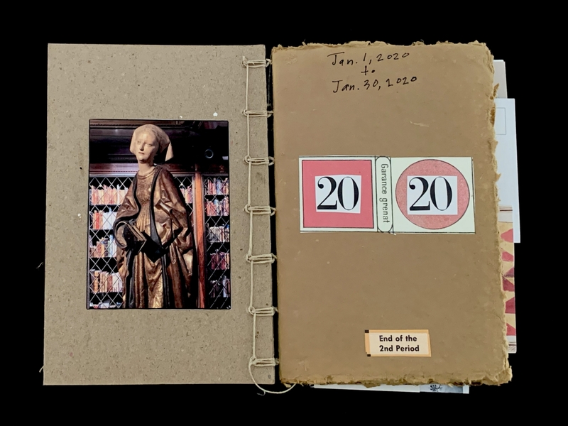 Open book showing a statue photo and date notes.