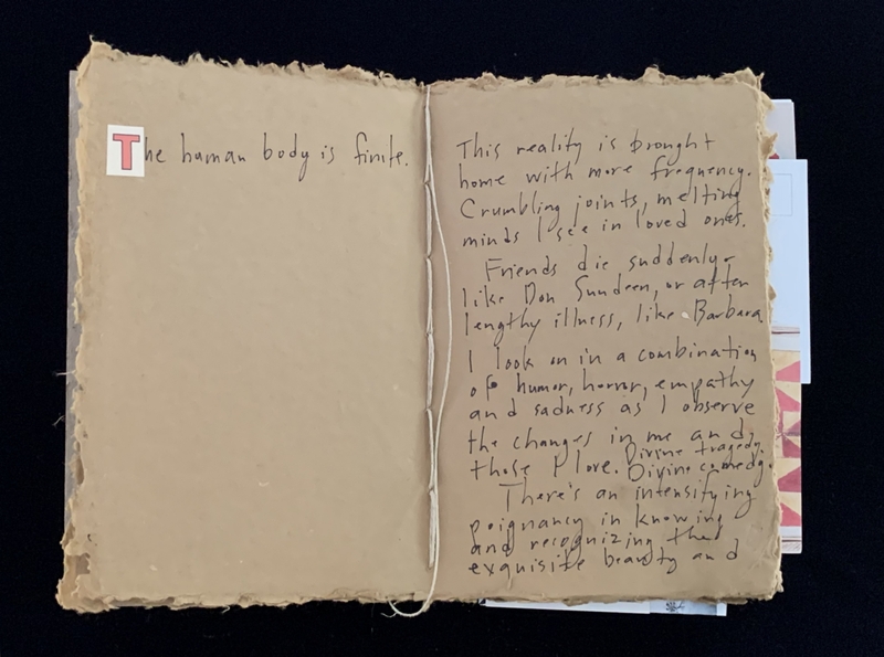 An open book with handwritten text on textured, light brown pages.