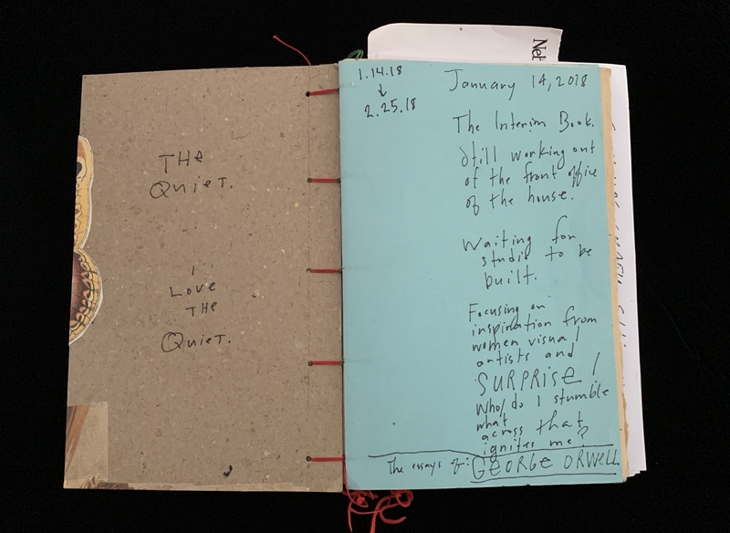 Open notebook showing handwritten notes on beige and blue pages.