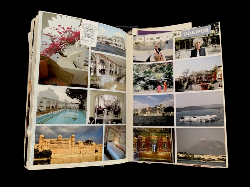 Open travel journal with photos and memorabilia from Udaipur, India.