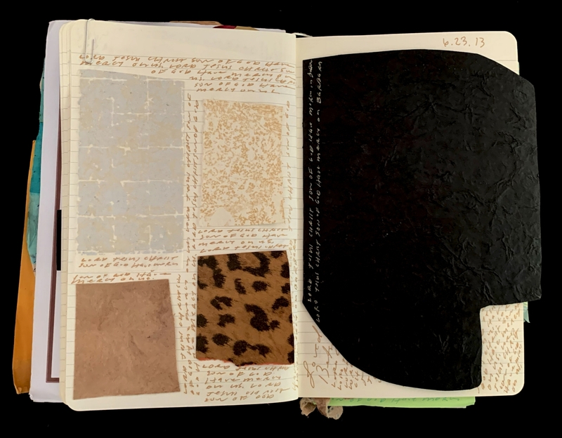 An open notebook with material samples and handwritten notes on the left page, and a black textured material covering the right page.