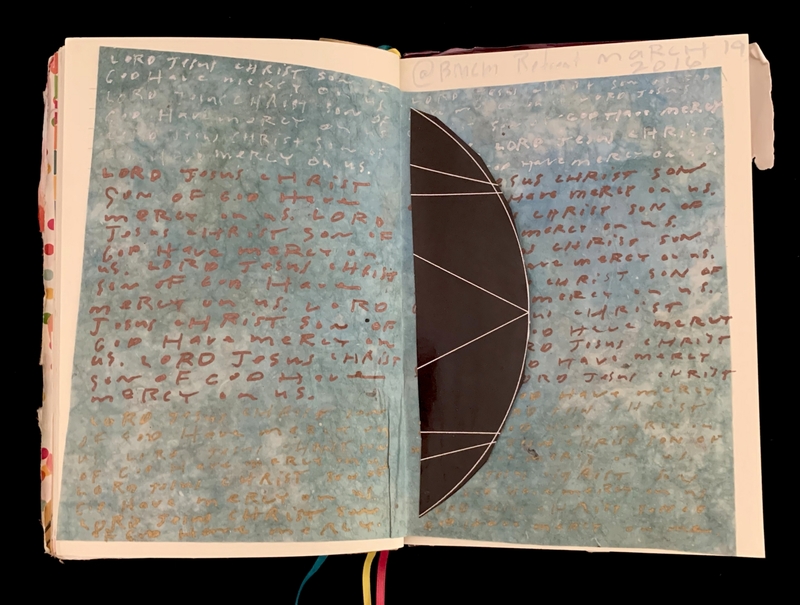 Open journal with handwritten text in red and white on a blue background, and an artistic dark semi-circle on the right.