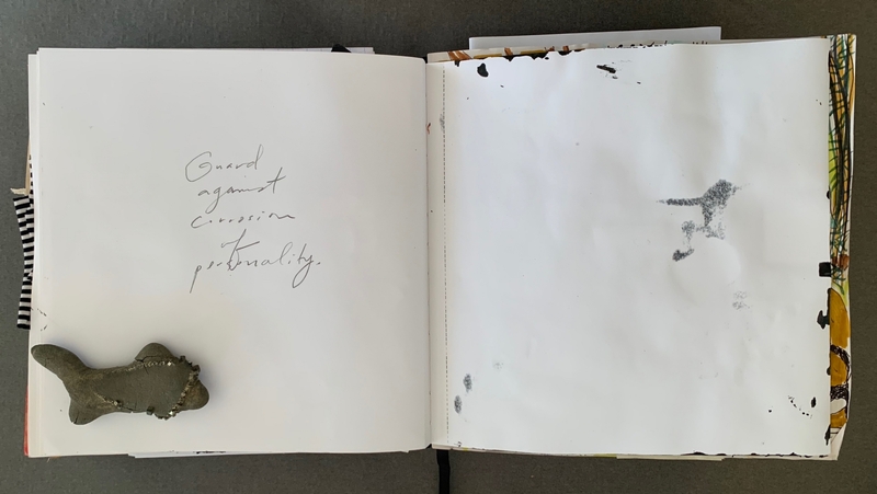 A journal page with a handwritten note and a small object placed on the left page.