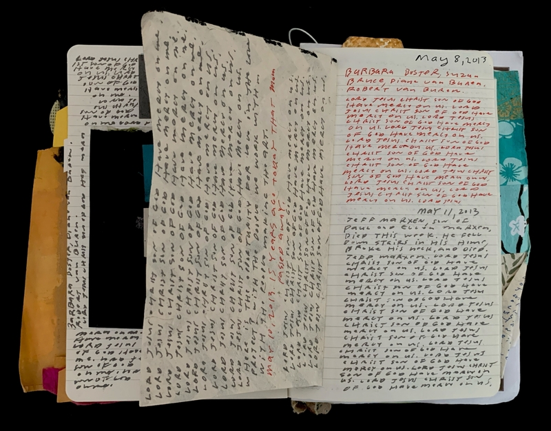 Open notebook with handwritten entries in black and red ink.