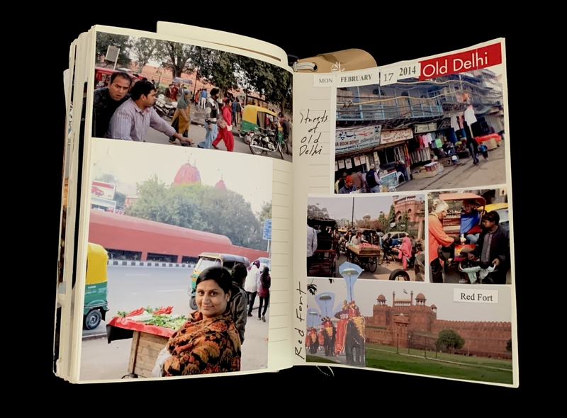 Open scrapbook showing photos of Old Delhi, including street scenes and the Red Fort, dated February 17, 2014.