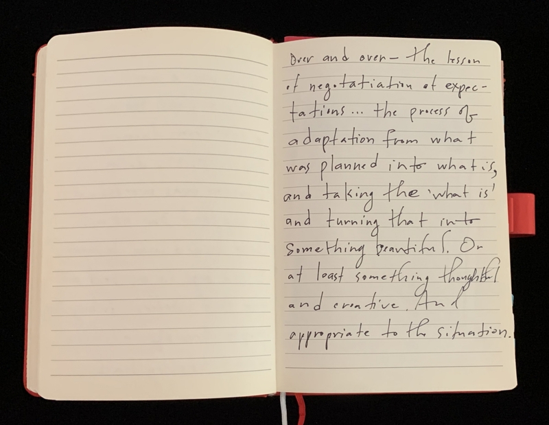 An open notebook with handwritten text on the right page and blank lines on the left.