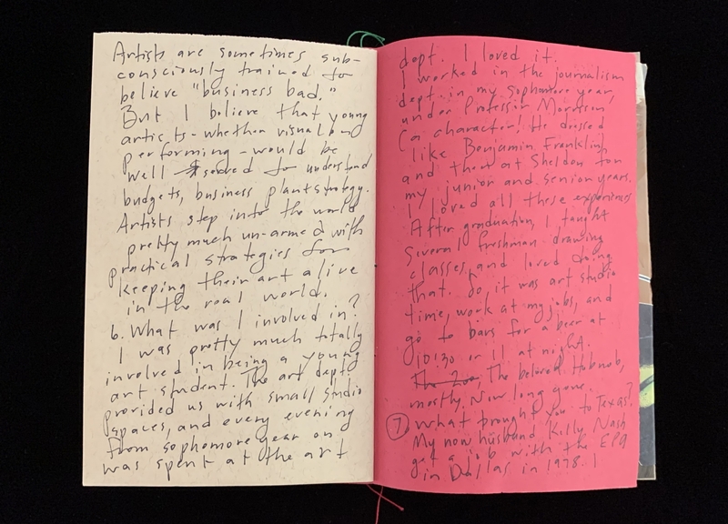 An open notebook with handwritten text on cream and pink pages.