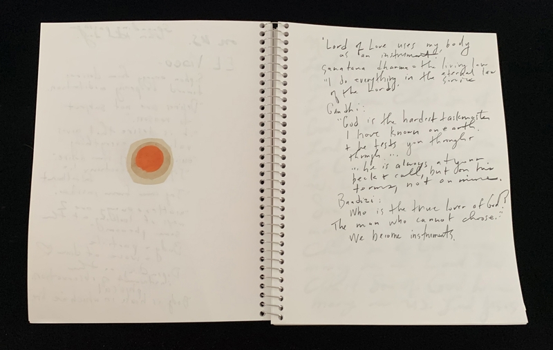 A handwritten page with a simple illustration of a sun and a spiral-bound notebook.