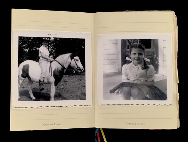 An open journal with black-and-white photos of a child on a horse and a girl on a porch.