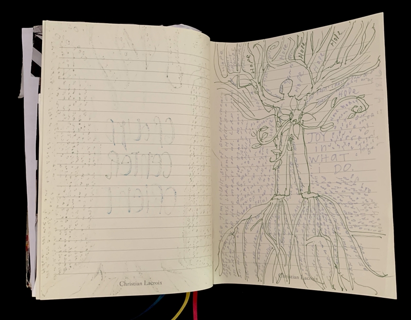 An open journal with a blank page and a human-tree drawing with text about hope and joy.