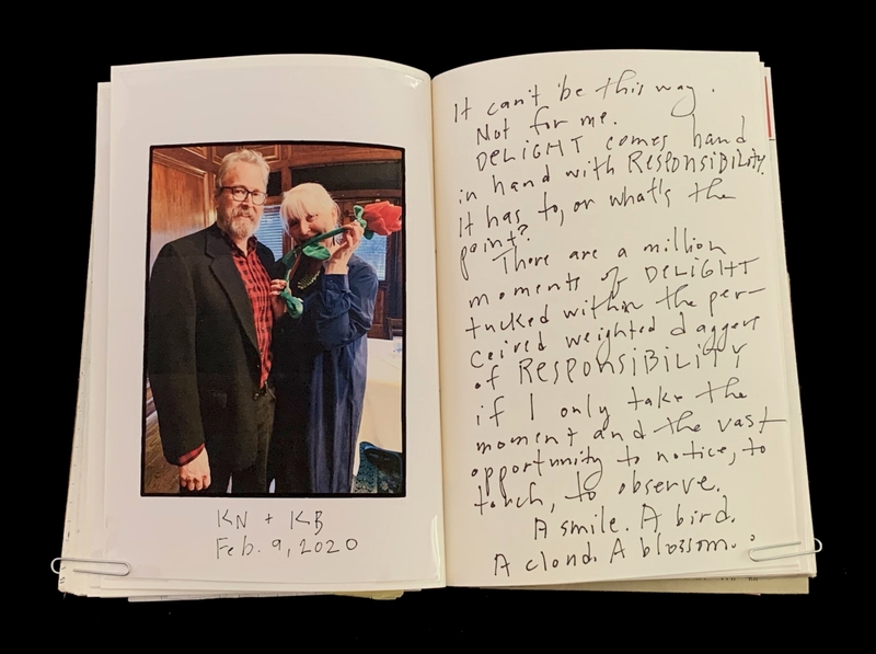 Open book with a photo of two people and handwritten text on opposite pages.