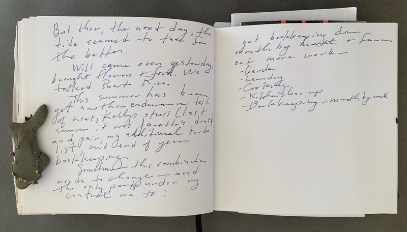 A handwritten journal page with notes and a small rock-like object.