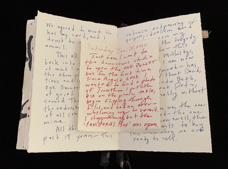 Open book with handwritten text in blue and red ink on cream paper.