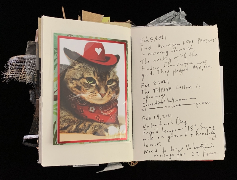 A journal page featuring a photograph of a cat wearing a red cowboy hat and a red bandana, alongside handwritten notes about various events and dates.