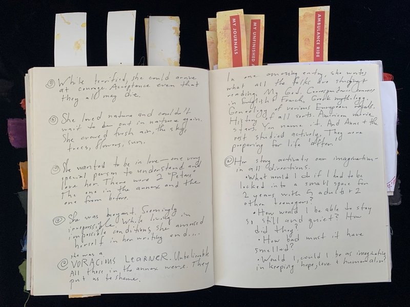 An open journal with handwritten text and sticky tabs.