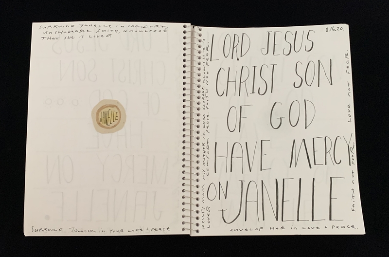 A handwritten prayer page with a circular sticker and various inscriptions.