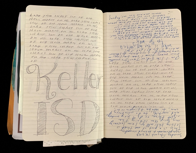 An open notebook with repetitive text and "Keller ISD" prominently on the left page and cursive writing on the right.