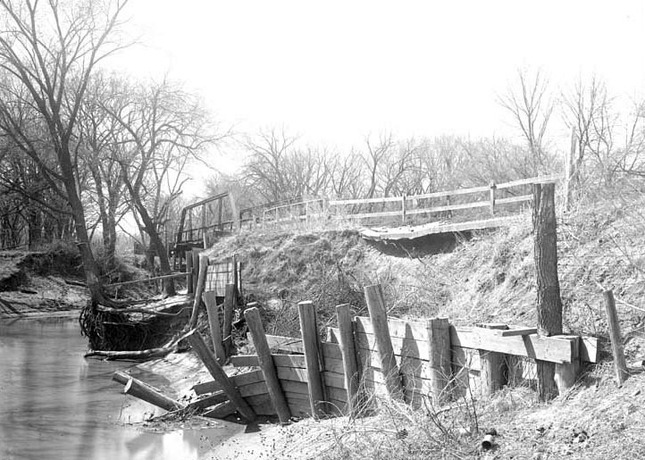 Original caption: Salt Creek bridge West of penitentiary showing damaged barricade and paving. Apr. 16, 1922
