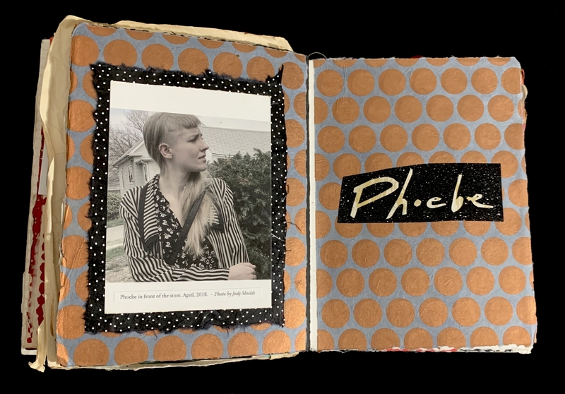 A scrapbook with a black and white photo on the left page and the name "Phoebe" on the right page.