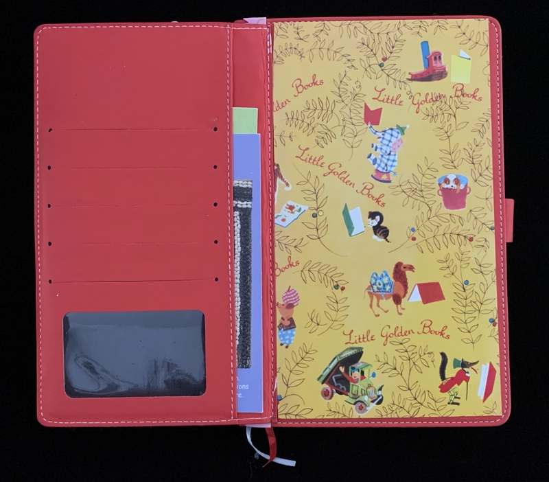Open red leather planner with slots and a vibrant "Little Golden Books" themed insert.