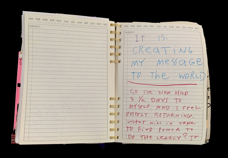 A handwritten note in a spiral-bound notebook discussing personal reflection and creating a message to the world.