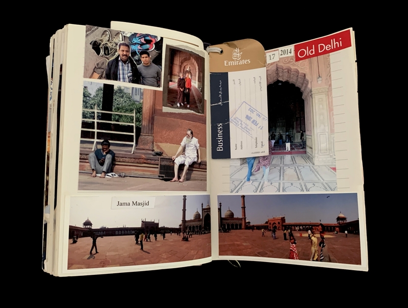 A travel scrapbook page featuring photographs and a business class ticket from Emirates Airlines, showcasing scenes from Old Delhi, India, including Jama Masjid.