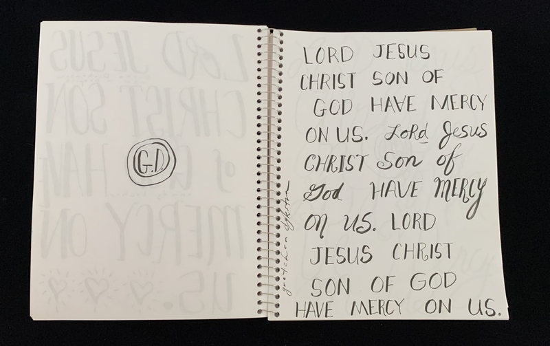 A handwritten page from a notebook with a prayer written in cursive.