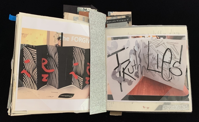 Open scrapbook with abstract designs, bold text, and a silver strip between pages.