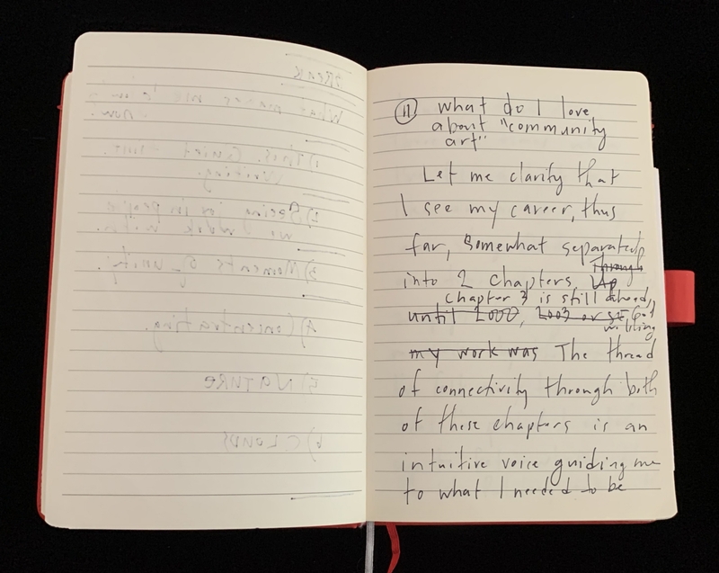 Open notebook with handwritten text about "community art."