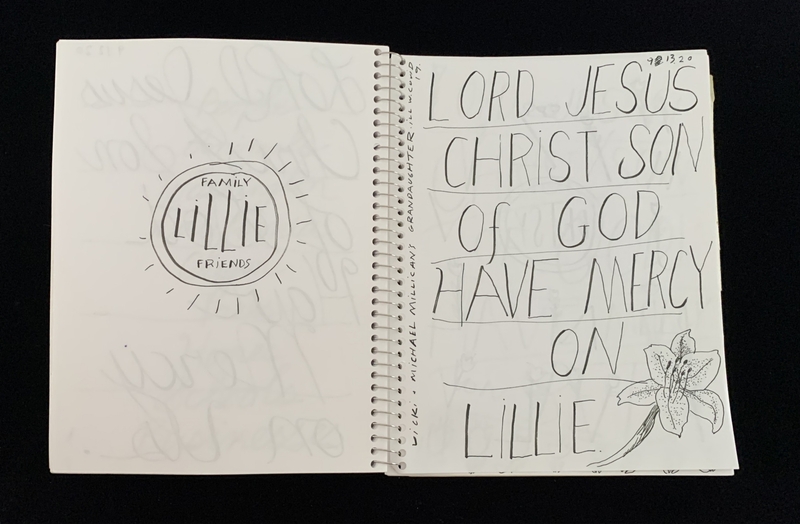 A handwritten page in a spiral notebook with a circular logo and a prayer for "Lillie."