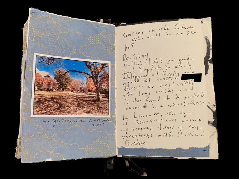 An open journal with a fall photograph on one side and handwritten notes on the other.