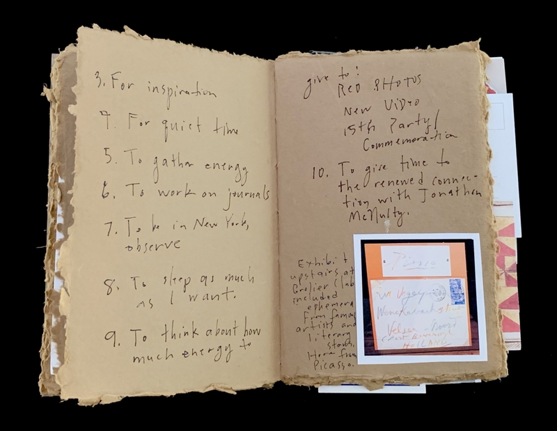 An open journal with handwritten notes and a small photo attached to one page.