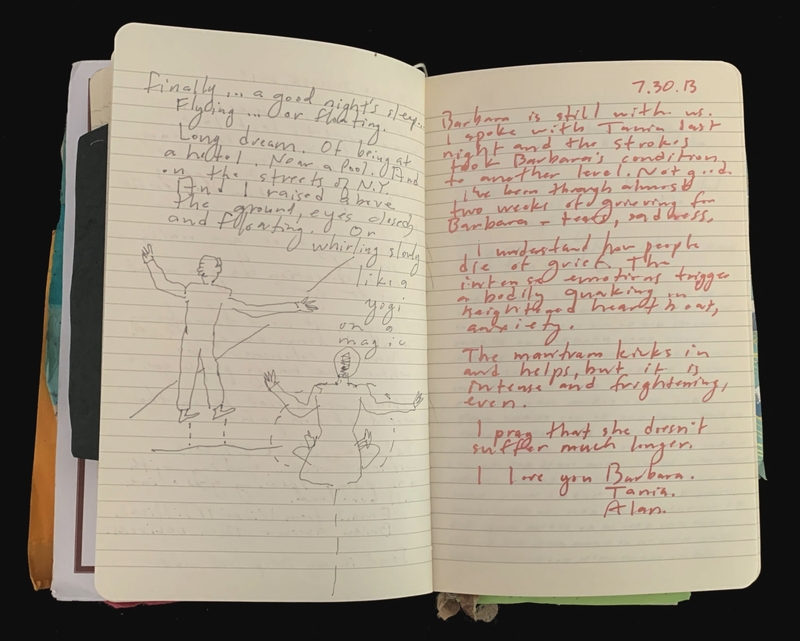 An open notebook with handwritten text and drawings, including standing and seated figures.