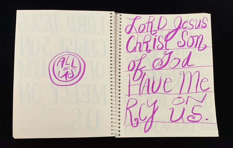 A handwritten prayer or devotion in a spiral-bound notebook with a circular logo on the left page.