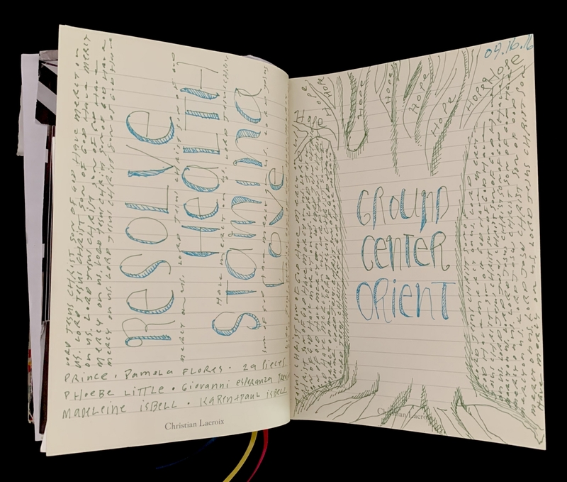 Open journal with handwritten text and tree illustration.
