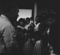 "Ca Mau" Crowd of young Vietnamese children around a man.